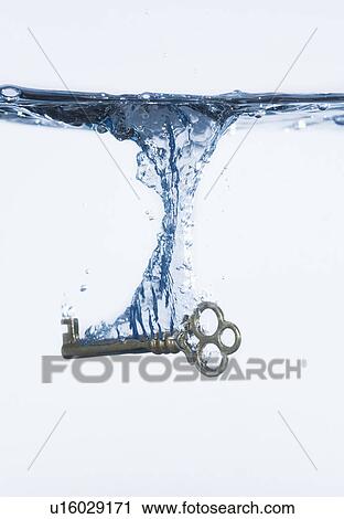 Silver key splashing into water, studio shot View Large Photo Image Stock Image - Silver key splashing into water, studio shot. Fotosearch