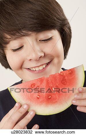 Studio portrait of boy (10-11) eating watermelon View Large Photo Image Stock Image - Studio portrait of boy (10-11) eating watermelon. Fotosearch