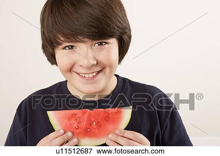 Studio portrait of boy (10-11) eating watermelon View Large Photo Image Stock Photo - Studio portrait of boy (10-11) eating watermelon. Fotosearch