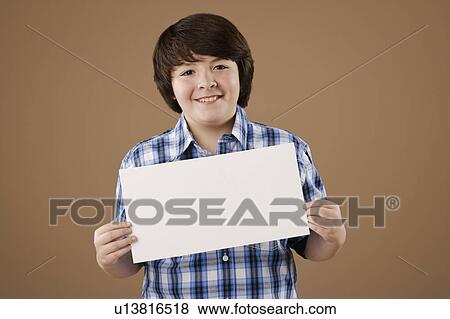 Studio portrait of boy (10-11) holding blank sheet of paper View Large Photo Image Stock Photo - Studio portrait of boy (10-11) holding blank sheet of paper. Fotosearch