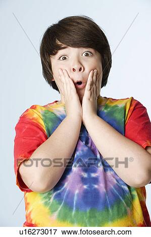 Stock Photo - Studio portrait of boy (10-11) in colorful shirt. Fotosearch