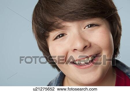 Stock Image - Studio portrait of boy (10-11) smiling. Fotosearch