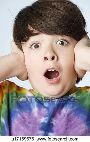 Stock Photograph - Studio portrait of boy (10-11) with head in hands. Fotosearch