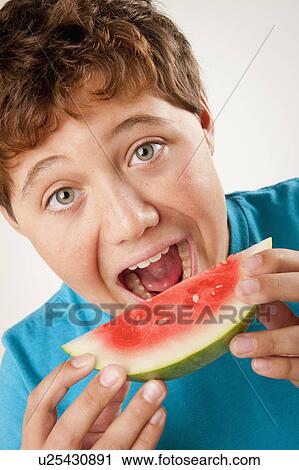 Studio portrait of boy (12-13) eating watermelon View Large Photo Image Stock Image - Studio portrait of boy (12-13) eating watermelon. Fotosearch