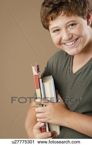 Studio portrait of boy (12-13) holding books View Large Photo Image Stock Image - Studio portrait of boy (12-13) holding books. Fotosearch