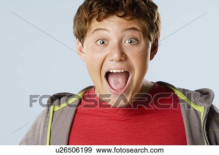 Stock Photo - Studio portrait of boy (12-13) looking surprised. Fotosearch