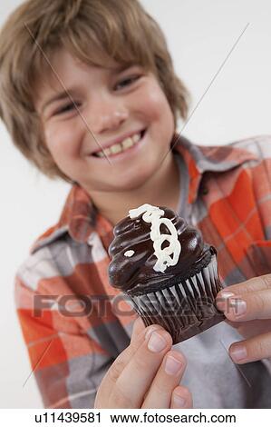 Studio portrait of boy (8-9) holding cake View Large Photo Image Stock Image - Studio portrait of boy (8-9) holding cake. Fotosearch