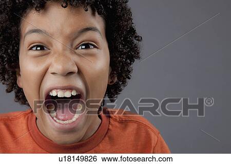 Stock Photograph - Studio portrait of boy (8-9) screaming. Fotosearch