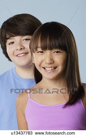 Stock Image - Studio portrait of boy and girl (10-11). Fotosearch