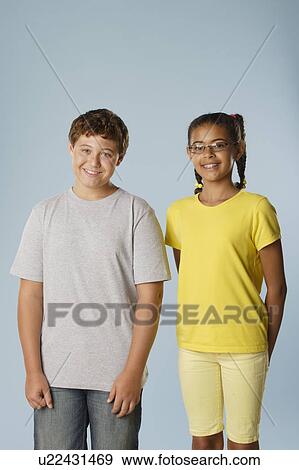 Stock Photo - Studio portrait of boy and girl (10-11, 12-13). Fotosearch