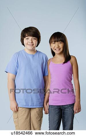 Stock Photograph - Studio portrait of boy and girl (10-11). Fotosearch