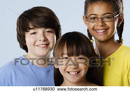 Stock Image - Studio portrait of boy and girls (10-11). Fotosearch