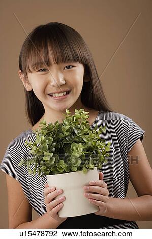 Studio portrait of girl (10-11) holding potted plant View Large Photo Image Stock Image - Studio portrait of girl (10-11) holding potted plant. Fotosearch