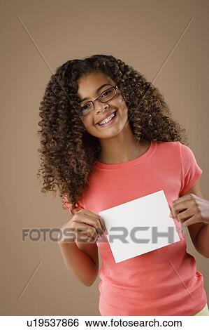 Studio portrait of girl (10-11) holding blank sheet of paper View Large Photo Image Stock Photograph - Studio portrait of girl (10-11) holding blank sheet of paper. Fotosearch