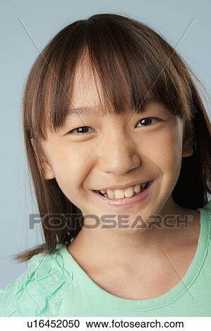 Stock Image - Studio portrait of girl (10-11) smiling. Fotosearch