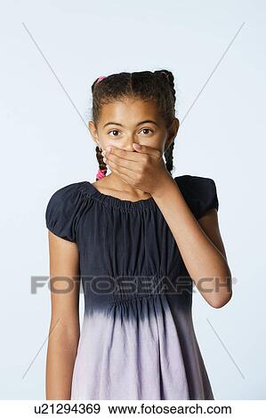Studio portrait of girl (10-11) covering mouth with hand View Large Photo Image Stock Photo - Studio portrait of girl (10-11) covering mouth with hand. Fotosearch