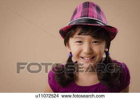 Picture - Studio portrait of girl (10-11) wearing hat. Fotosearch