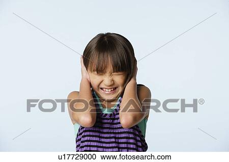 Stock Image - Studio portrait of girl (10-11) with head in hands. Fotosearch