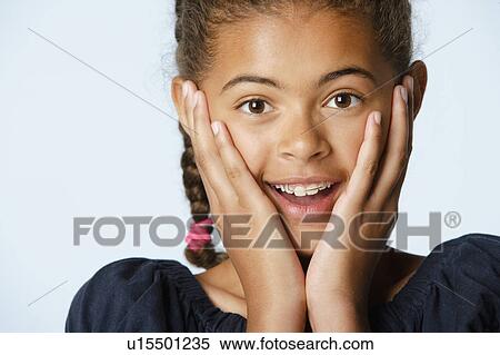 Stock Photography - Studio portrait of girl (10-11) with head in hands. Fotosearch