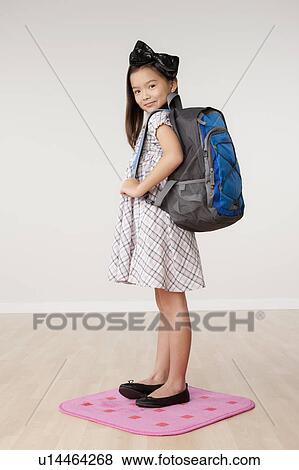 Studio portrait of girl (8-9) carrying backpack View Large Photo Image Stock Photo - Studio portrait of girl (8-9) carrying backpack. Fotosearch