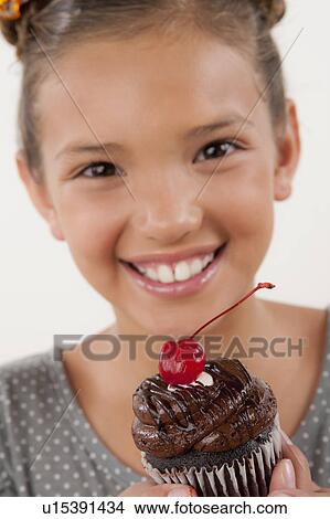 Studio portrait of girl (8-9) holding cake View Large Photo Image Picture - Studio portrait of girl (8-9) holding cake. Fotosearch