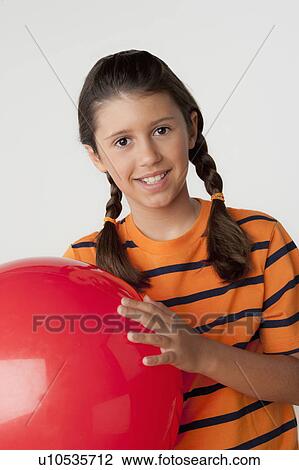 Studio portrait of girl (8-9) holding red ball View Large Photo Image Stock Image - Studio portrait of girl (8-9) holding red ball. Fotosearch