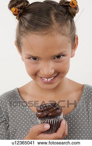 Studio portrait of girl (8-9) holding cake View Large Photo Image Stock Image - Studio portrait of girl (8-9) holding cake. Fotosearch
