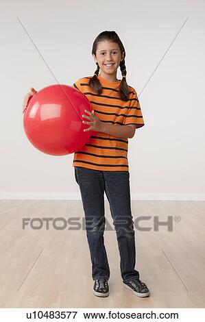 Studio portrait of girl (8-9) holding red ball View Large Photo Image Stock Photo - Studio portrait of girl (8-9) holding red ball. Fotosearch