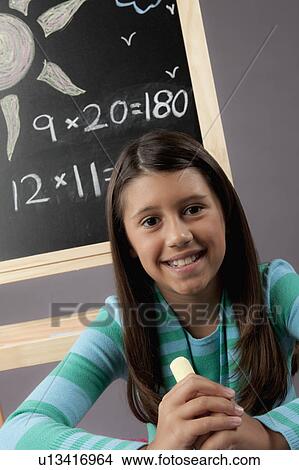 Picture - Studio portrait of girl (8-9) next to blackboard. Fotosearch
