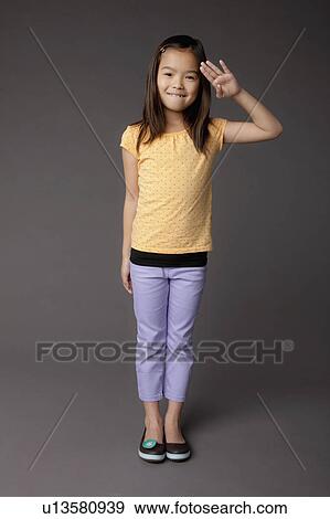 Stock Photo - Studio portrait of girl (8-9) saluting. Fotosearch