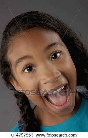Stock Image - Studio portrait of girl (8-9) shouting. Fotosearch