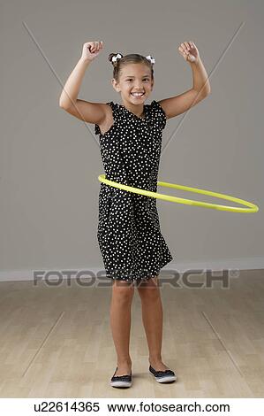 Studio portrait of girl (8-9) spinning plastic hoop View Large Photo Image Stock Photography - Studio portrait of girl (8-9) spinning plastic hoop. Fotosearch