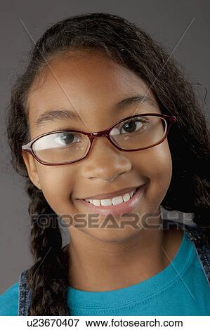 Studio portrait of girl (8-9) wearing eyeglasses View Large Photo Image Stock Photo - Studio portrait of girl (8-9) wearing eyeglasses. Fotosearch