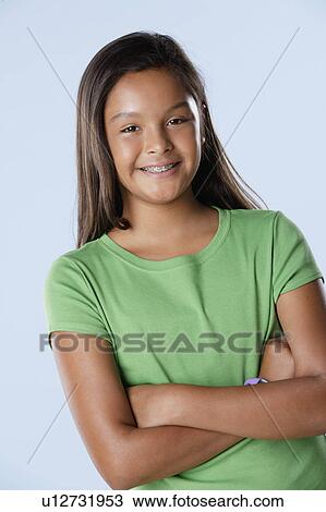 Stock Image - Studio portrait of girl smiling (10-11). Fotosearch