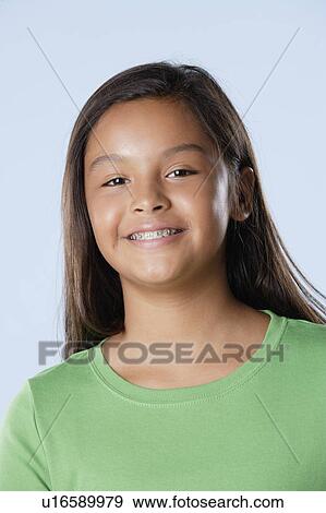 Stock Photo - Studio portrait of girl smiling (10-11). Fotosearch