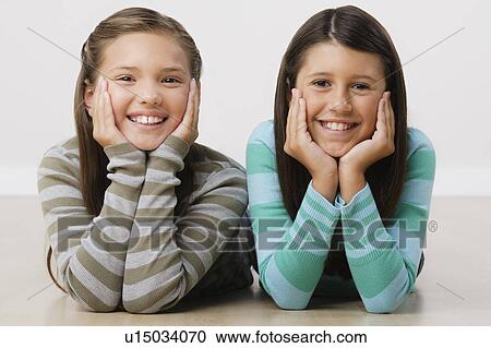 Studio portrait of two girls (8-9) lying on floor View Large Photo Image Stock Image - Studio portrait of two girls (8-9) lying on floor. Fotosearch