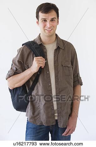 Studio portrait of young man carrying backpack View Large Photo Image Stock Image - Studio portrait of young man carrying backpack. Fotosearch