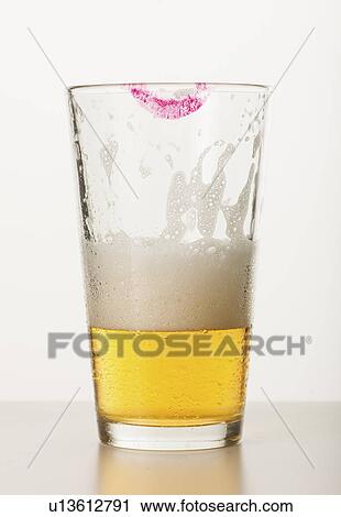 Stock Image - Studio shot of beer glass with lipstick mark on edge. Fotosearch