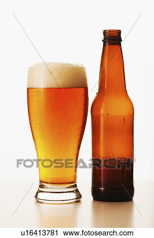 Stock Image - Studio shot of bitter ale in bottle and glass. Fotosearch