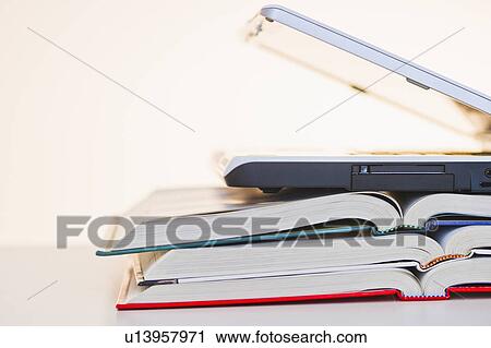 Stock Image - Studio shot of books and laptop. Fotosearch