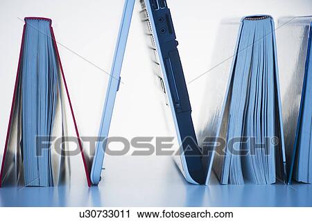 Stock Image - Studio shot of books and laptop. Fotosearch