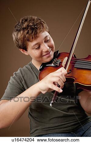 Studio shot of boy (12-13) playing violin View Large Photo Image Picture - Studio shot of boy (12-13) playing violin. Fotosearch
