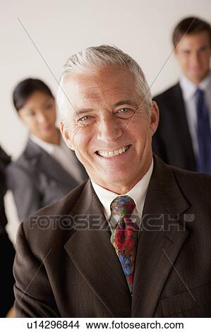 Picture - Studio shot of business people, focus on senior business man. Fotosearch