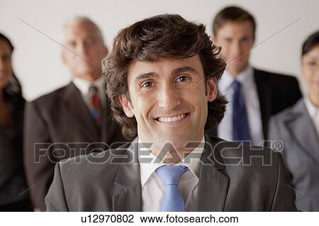 Stock Image - Studio shot of business people, focus on mid adult business man. Fotosearch