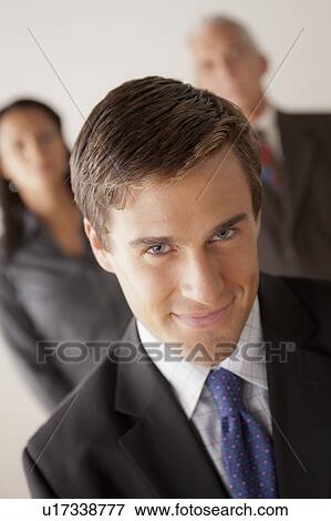 Stock Photo - Studio shot of business people, focus on young business man. Fotosearch