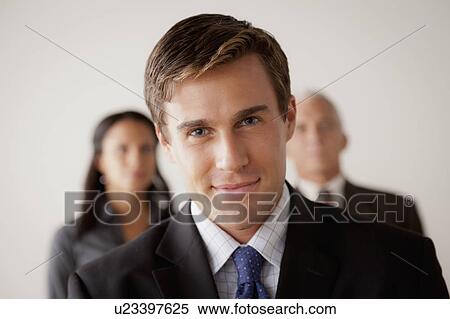 Stock Photography - Studio shot of business people, focus on young business man. Fotosearch
