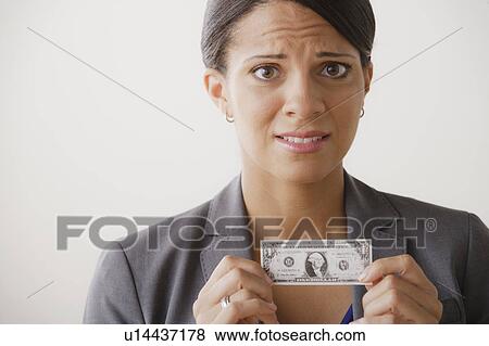 Studio shot of business woman holding small one dollar bill View Large Photo Image Stock Photo - Studio shot of business woman holding small one dollar bill. Fotosearch
