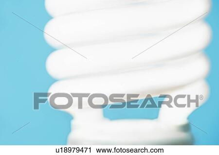 Stock Image - Studio shot of energy efficient lightbulb on blue background. Fotosearch