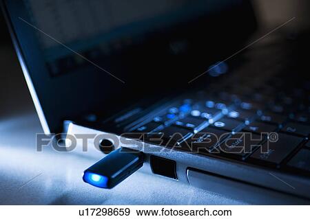 Stock Photo - Studio shot of flash drive in laptop. Fotosearch