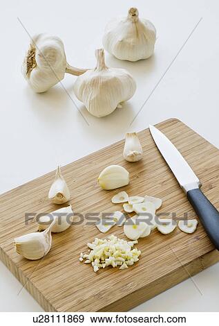 Studio shot of fresh garlic being chopped on cutting board View Large Photo Image Stock Photo - Studio shot of fresh garlic being chopped on cutting board. Fotosearch